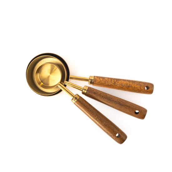 Set of 3 Golden stainless steel measuring spoons with wooden handle.